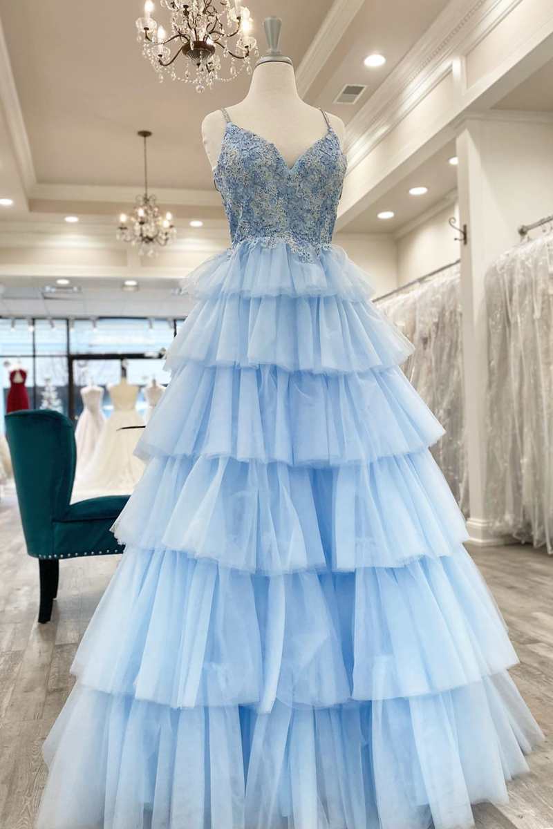 Woman wearing an elegant A-line lace V-neck prom dress, posing gracefully.