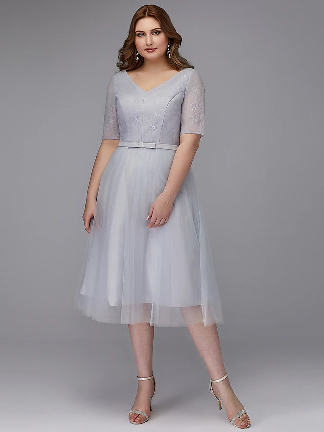 Model wearing elegant A-line lace wedding guest dress.