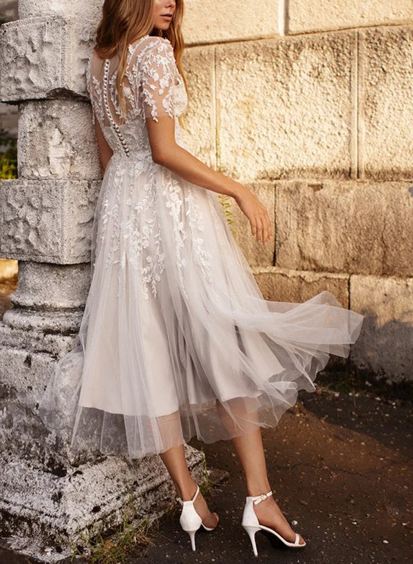 Back view of an A-line tulle wedding dress with short sleeves and lace details.