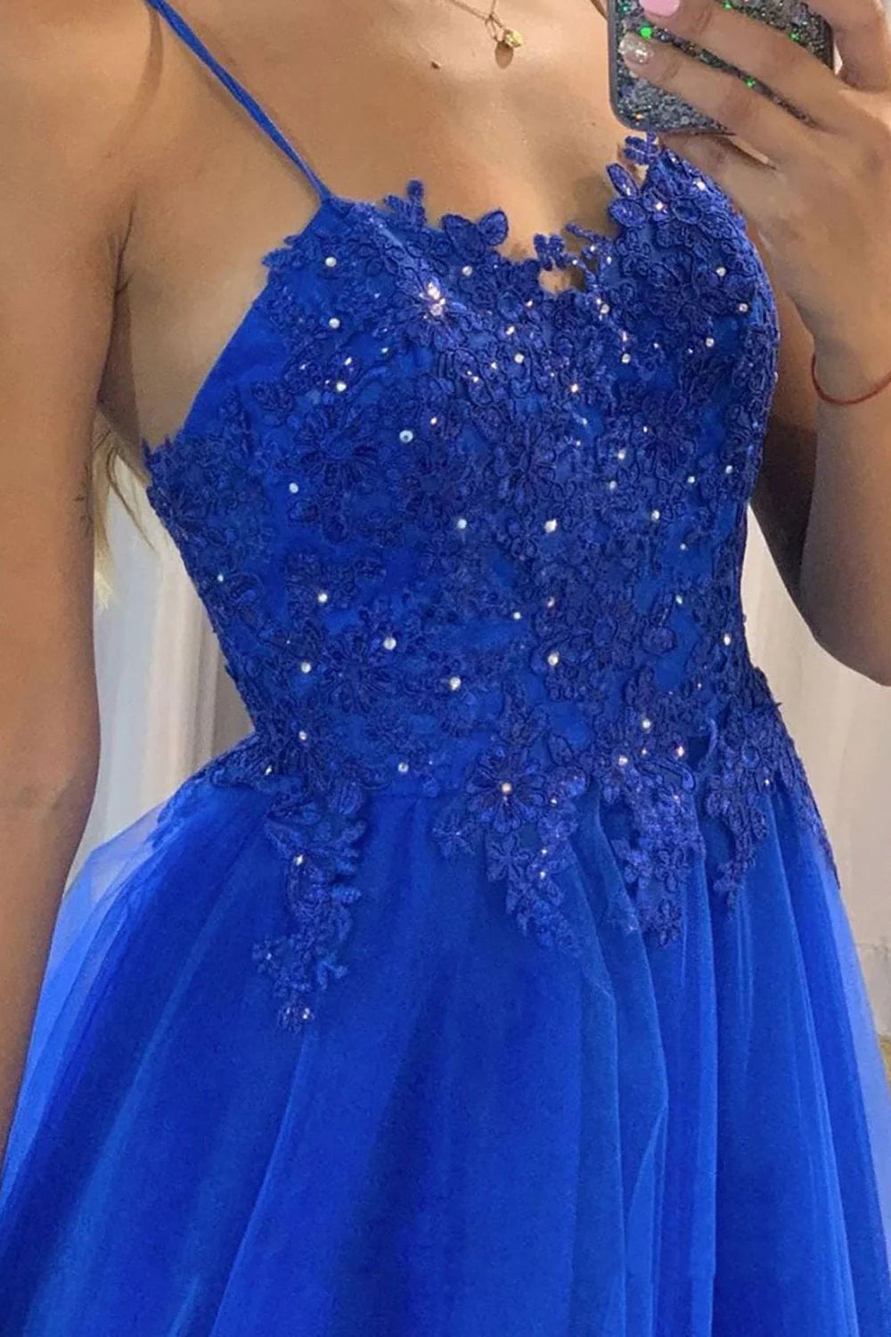 Back view of an A-line long prom dress with spaghetti straps and delicate beading.