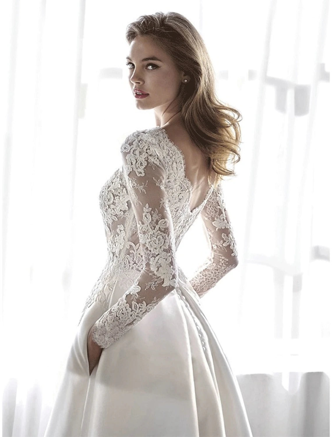 Full length view of elegant satin wedding gown with flowing chapel train.