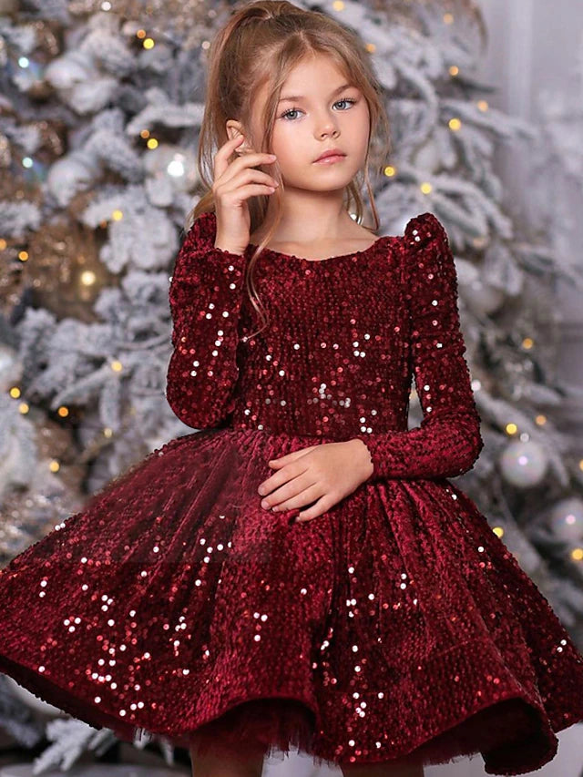 Little girl wearing a red A-line satin dress with sequins and ruched details.