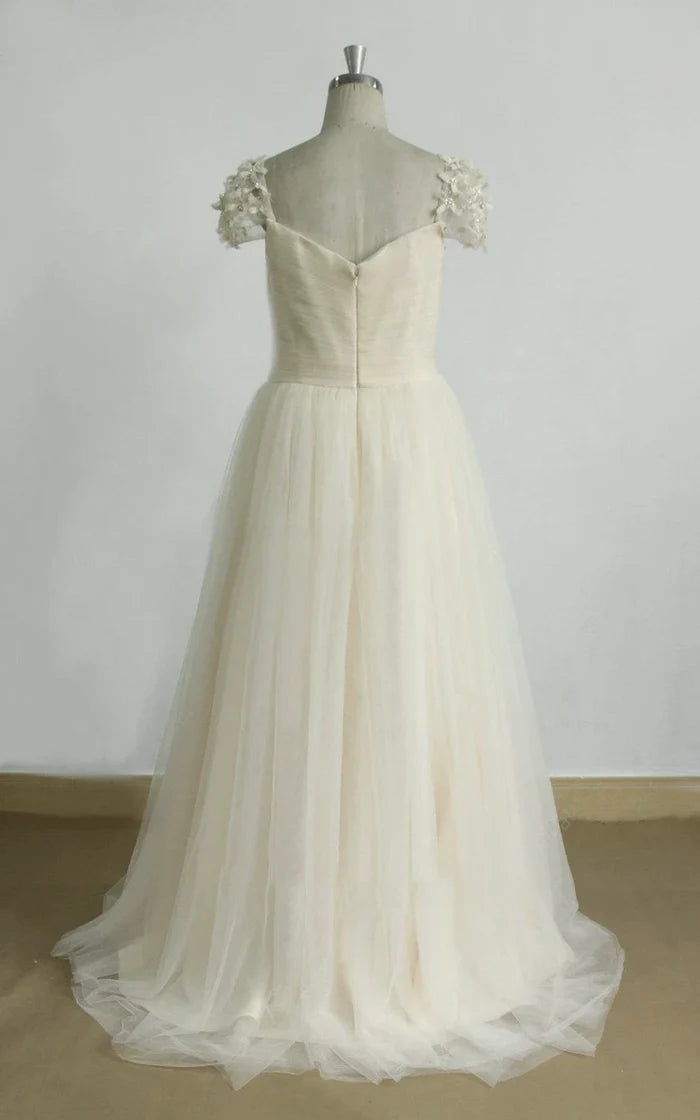 Back view of a white A-line bridal gown featuring long sleeves and a flowing tulle skirt.