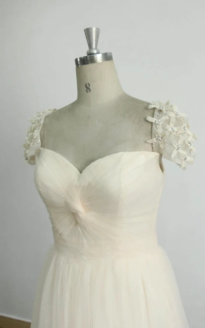 Front view of a romantic A-line wedding dress with a round neckline, long sleeves, and delicate lace.