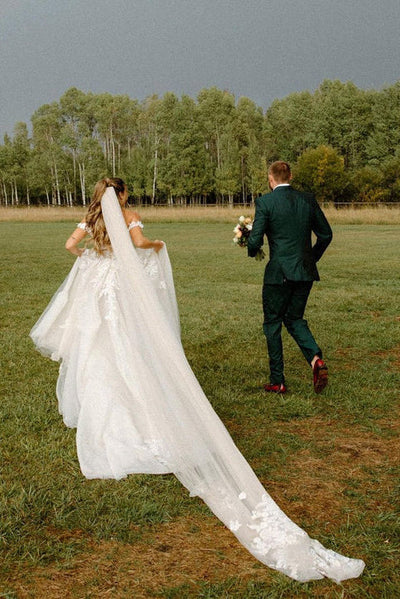 Long white wedding dress featuring an A-line silhouette and off-shoulder design.