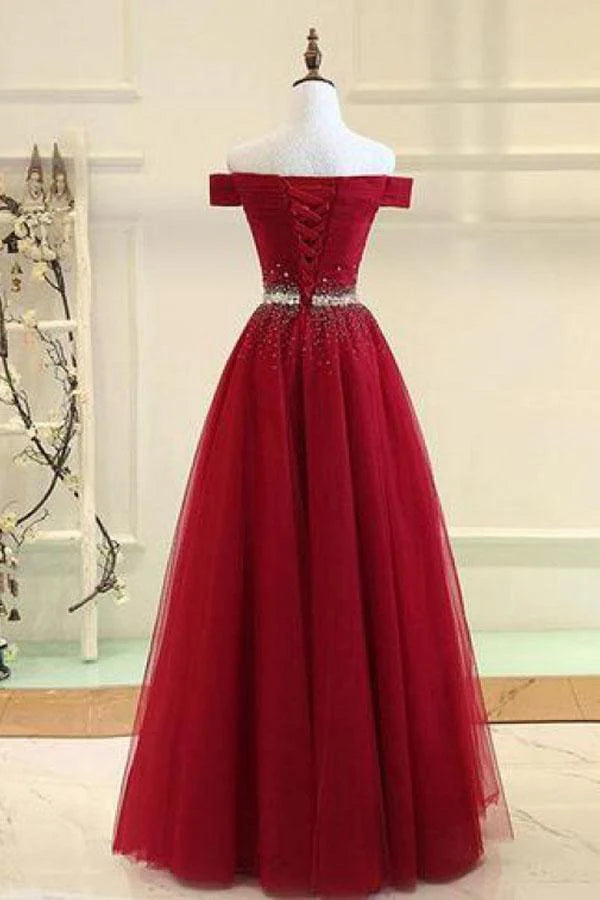 Side view of an A-line off-shoulder beaded tulle prom dress.