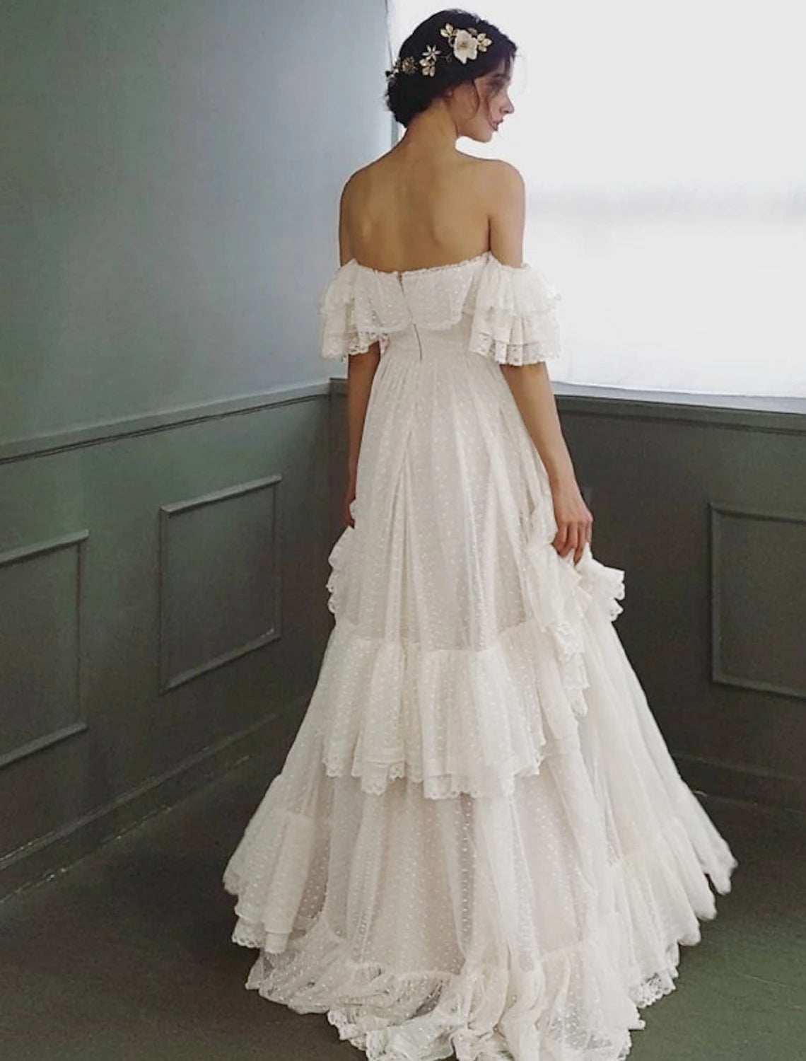 Back view of the A-line off-shoulder cap sleeve tulle wedding dress with ruffles.