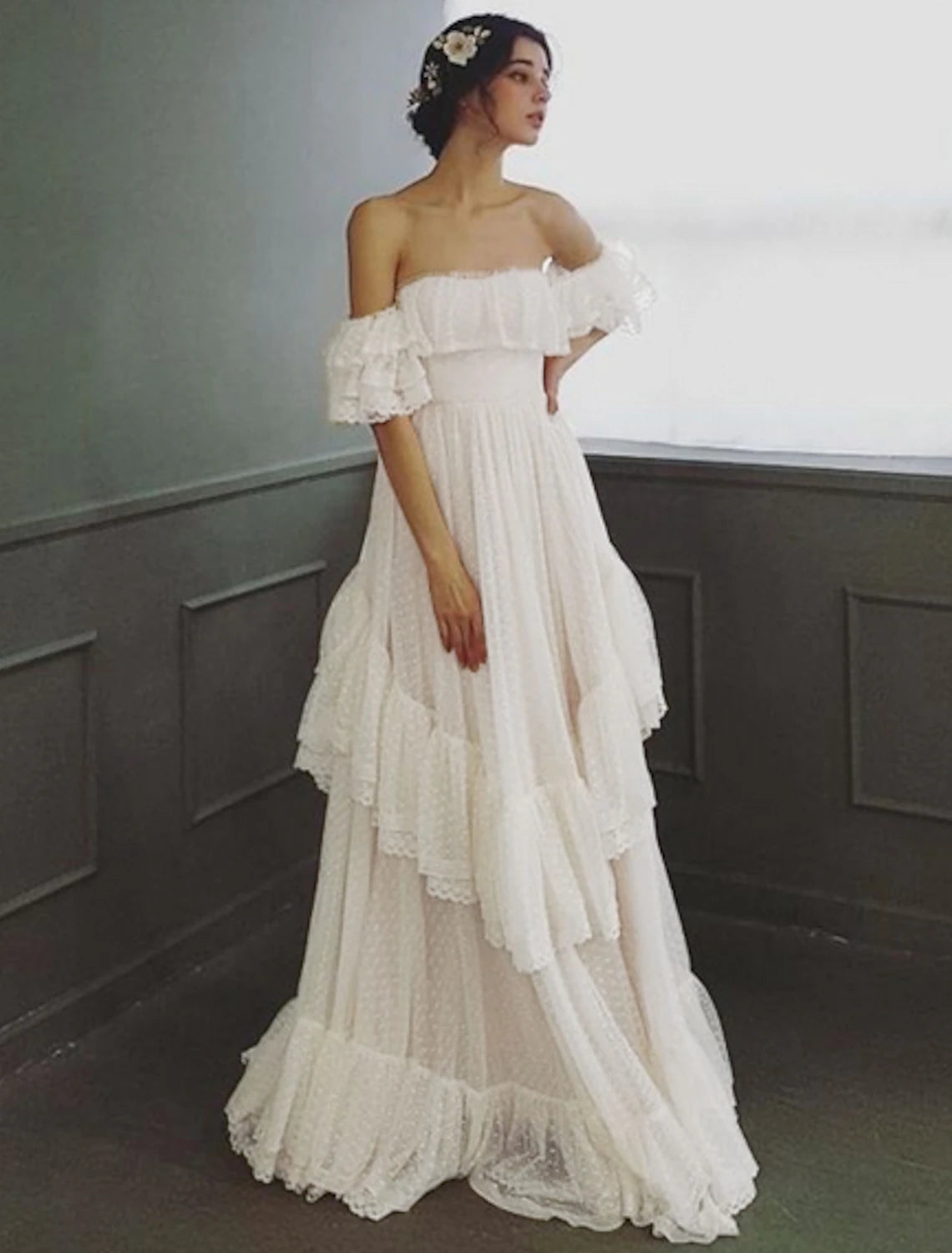 Close-up of the ruffled tulle fabric and off-shoulder neckline of the wedding dress.