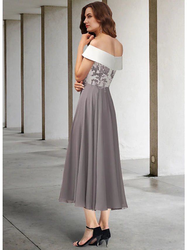 Close-up of chiffon and lace details with appliques and pleats on the tea-length dress.