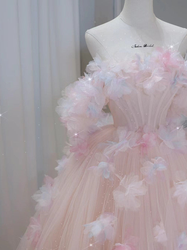 Close-up of delicate floral appliques on a tulle off-shoulder prom dress.