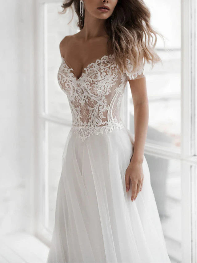 Side profile of a bride wearing an A-line off-shoulder lace wedding dress.