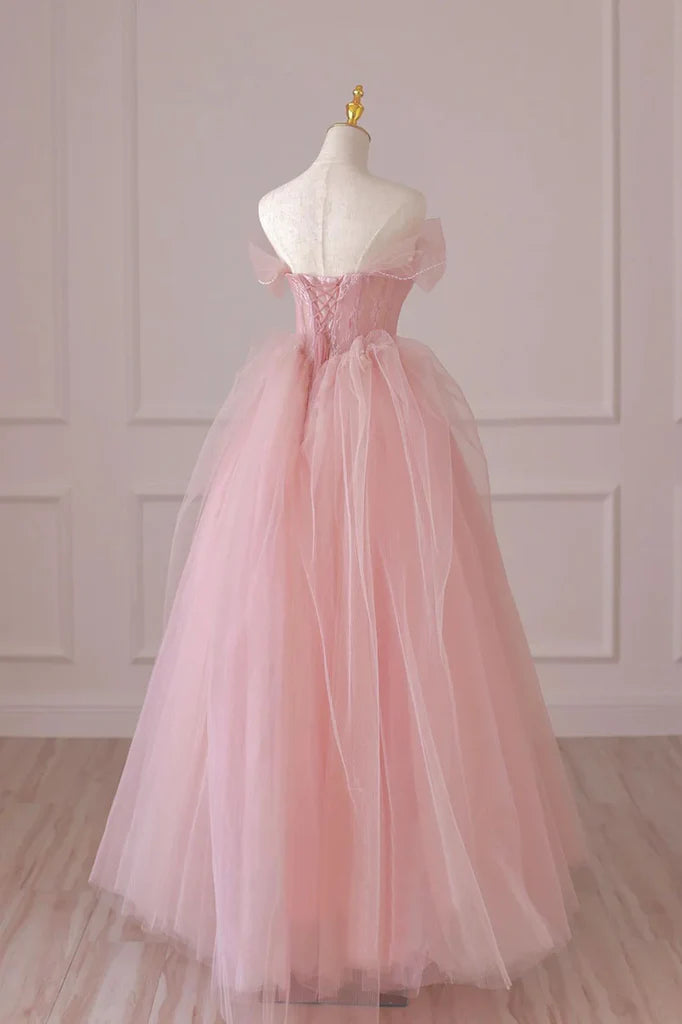 Side view of a woman in a flowing A-line off-shoulder lace prom gown.