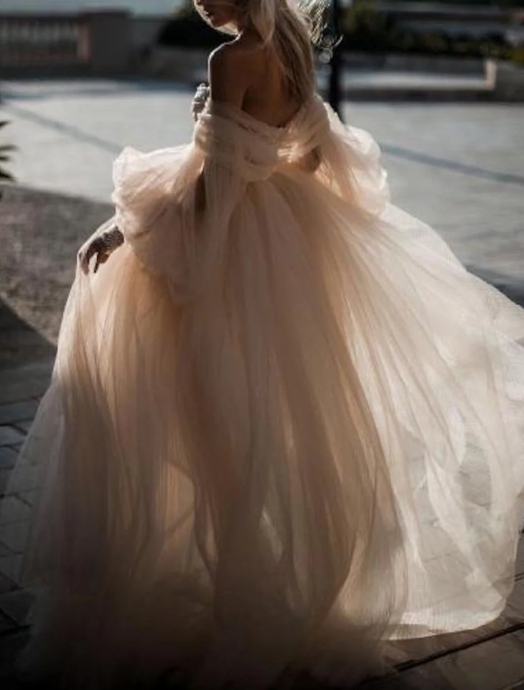 Side view of a bride wearing a floor-length lace wedding gown.