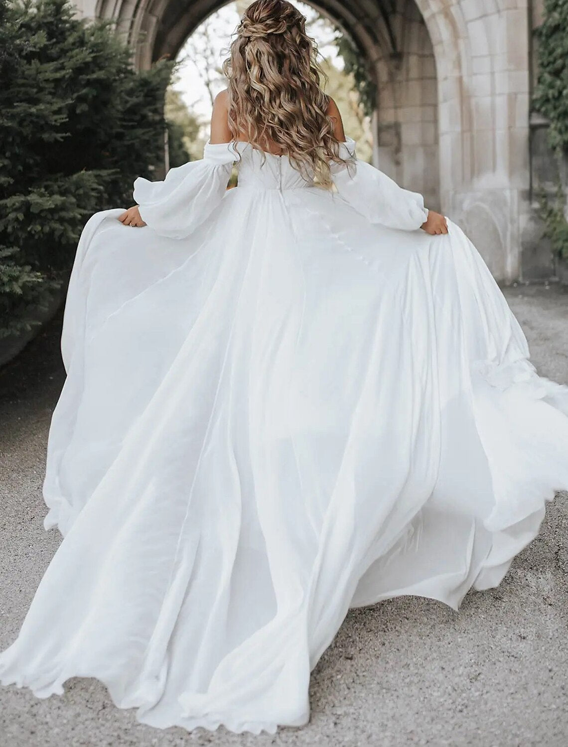 Close-up of the off-shoulder neckline and long sleeves of the chiffon wedding dress.