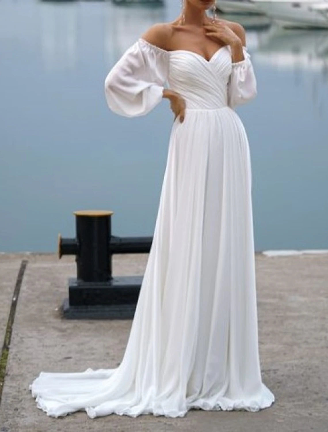Side view of an elegant off-shoulder long sleeve ruched chiffon wedding dress.