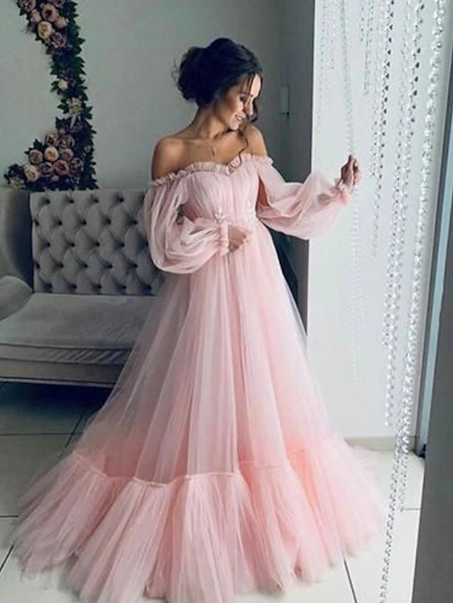 Woman wearing an elegant A-line off-shoulder long sleeve tulle prom dress.