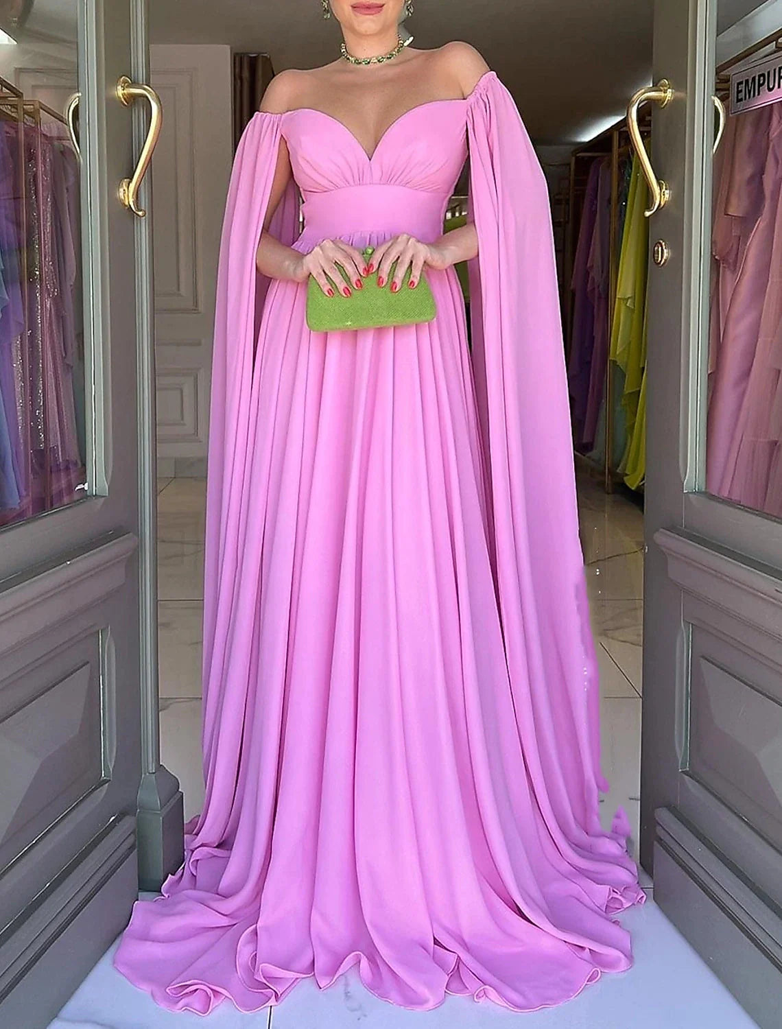 Close-up of the off-shoulder neckline and pleated chiffon fabric of the gown.