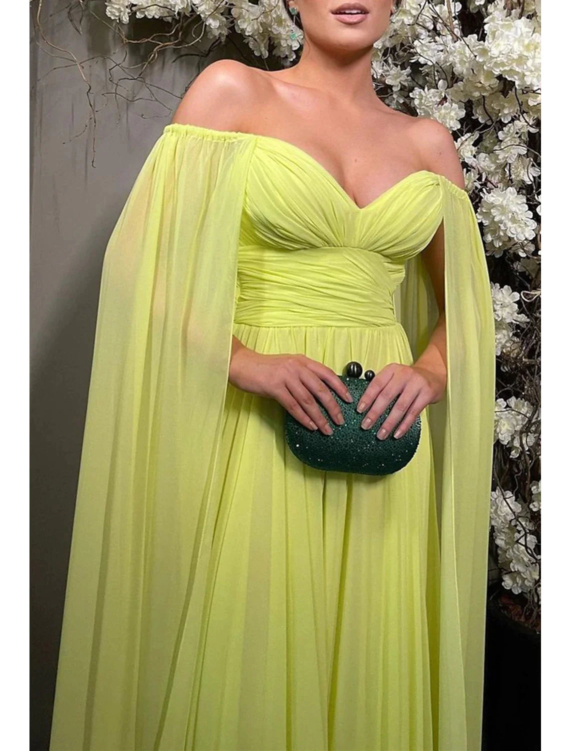 Woman in a dark-colored A-line off-shoulder evening gown, showcasing the sweep train.