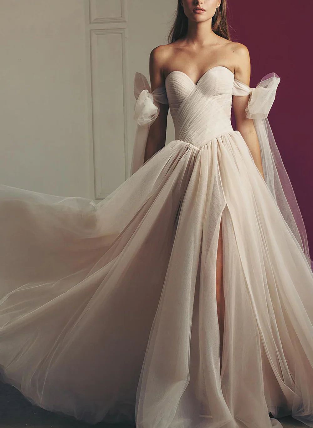 Close-up of the pleated tulle fabric and off-shoulder neckline of a wedding gown.
