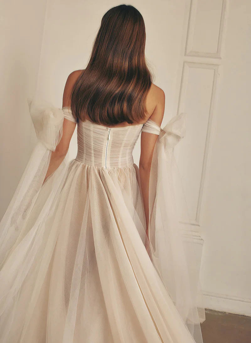 Full length view of a bride posing in an elegant A-line wedding dress with a front slit.