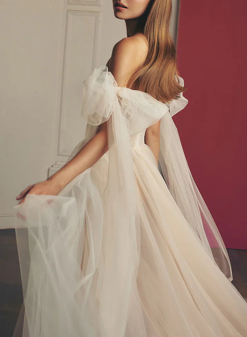 Side view of the A-line off-shoulder wedding dress, highlighting the silhouette and slit.