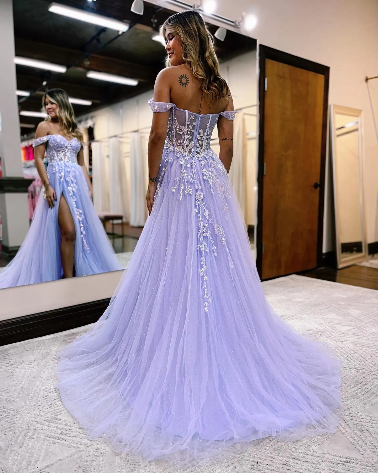 A-line off-shoulder prom dress with intricate appliques, side view.