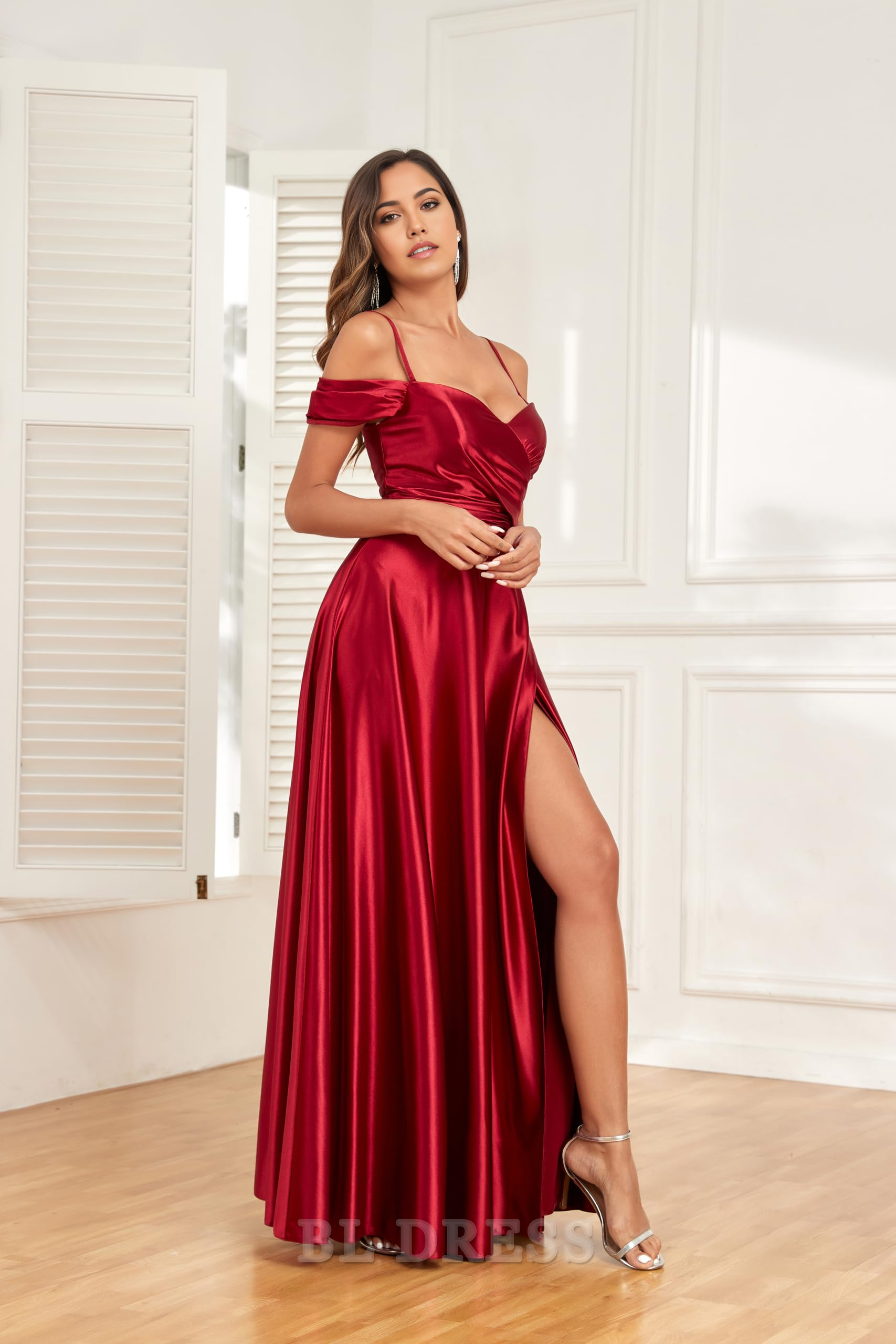 Model wearing an elegant A-line off-shoulder satin formal dress with ruched details and a high slit.