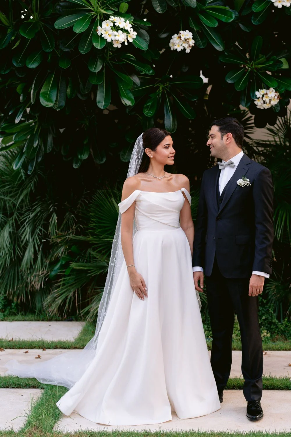 Back view of the white A-line off-shoulder wedding dress with ruched details.