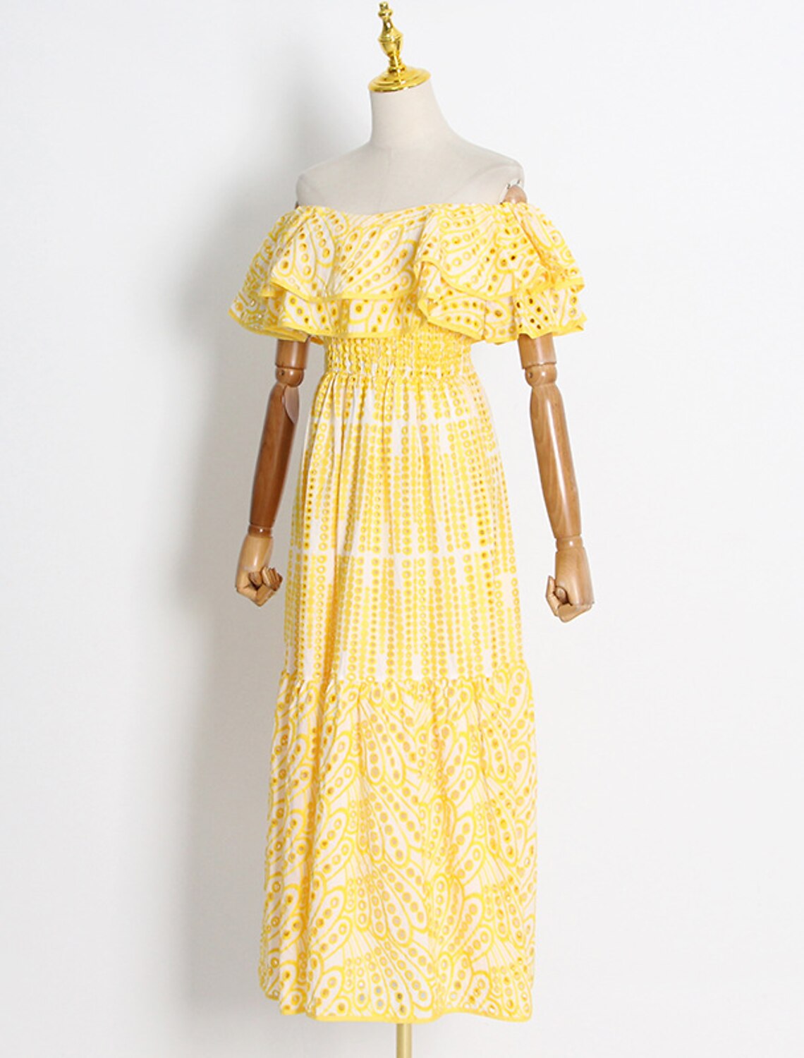 Woman wearing an elegant light blue A-line off-shoulder dress with ruffles and embroidery.