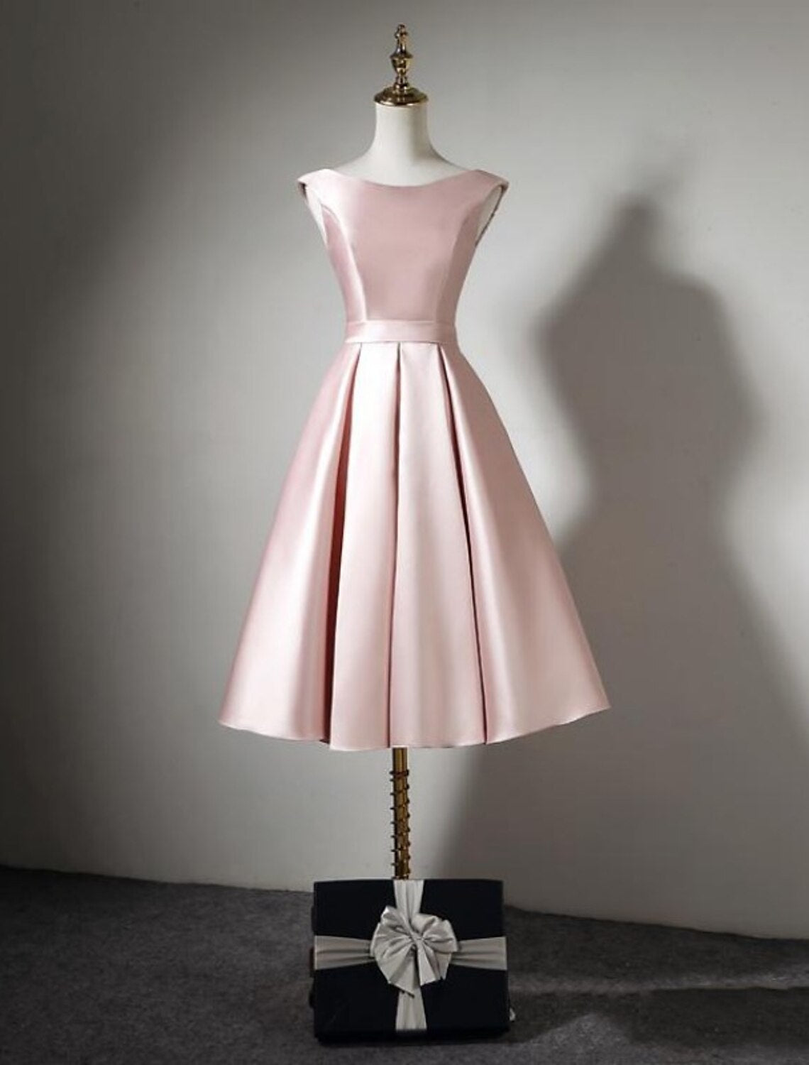 Side view of tea-length satin bridesmaid dress with pleats.