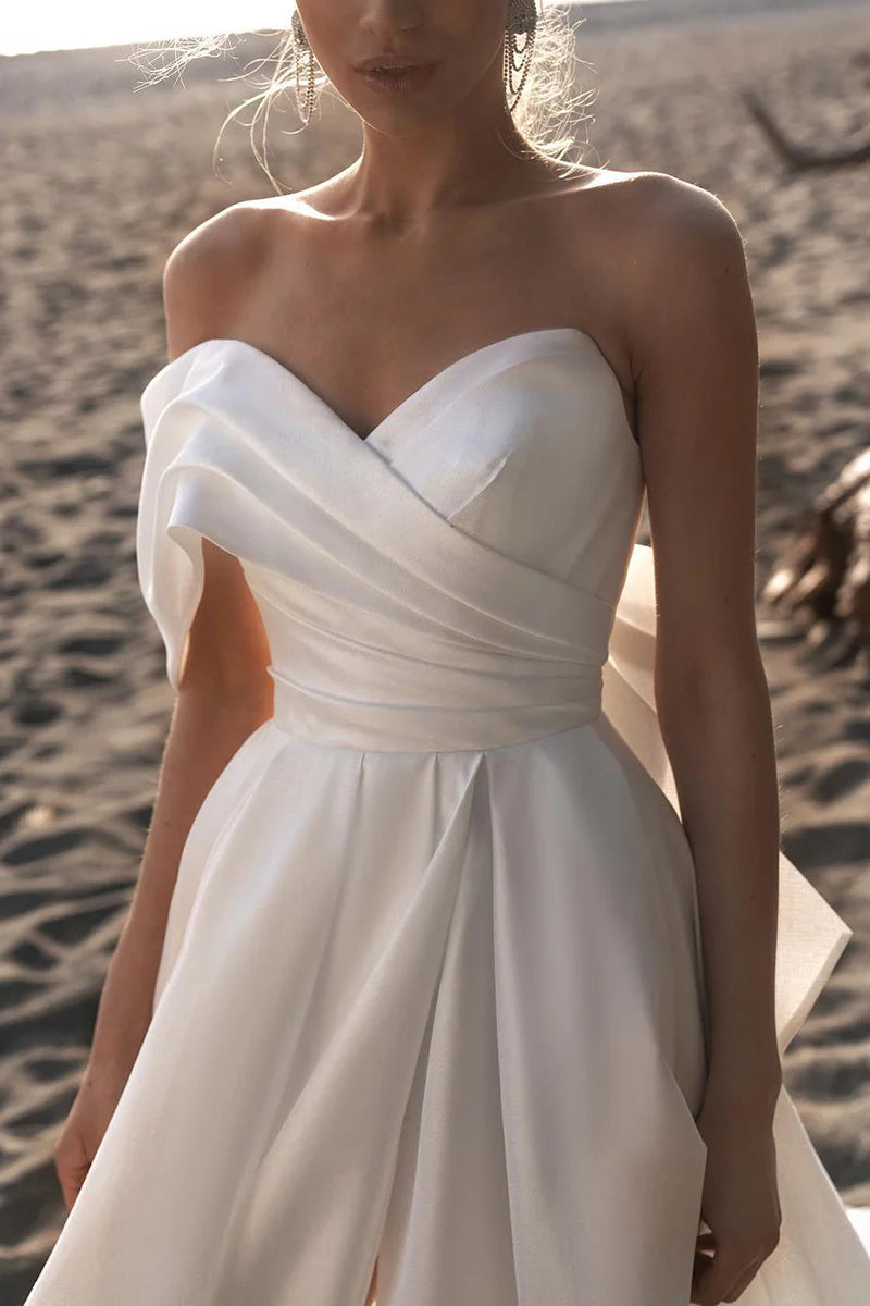 Detail of the luxurious satin fabric and pleating on the wedding dress.