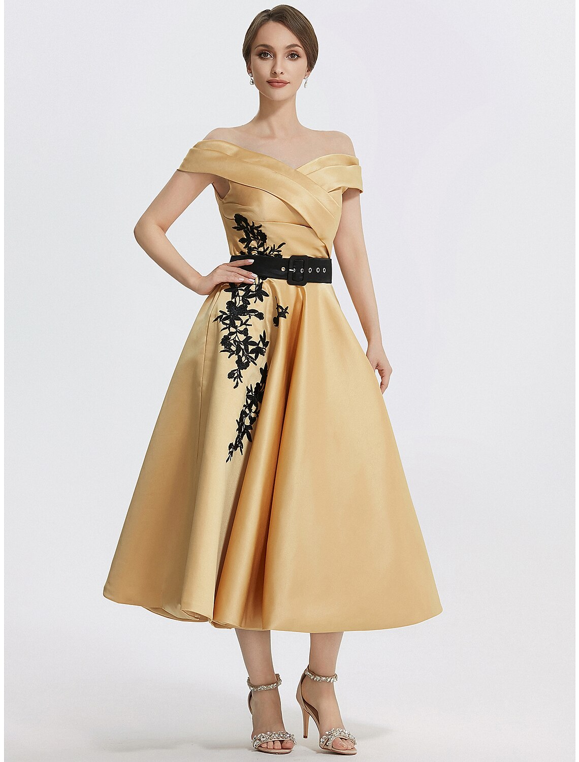 Model wearing an elegant A-line off-shoulder satin tea length dress with appliques.