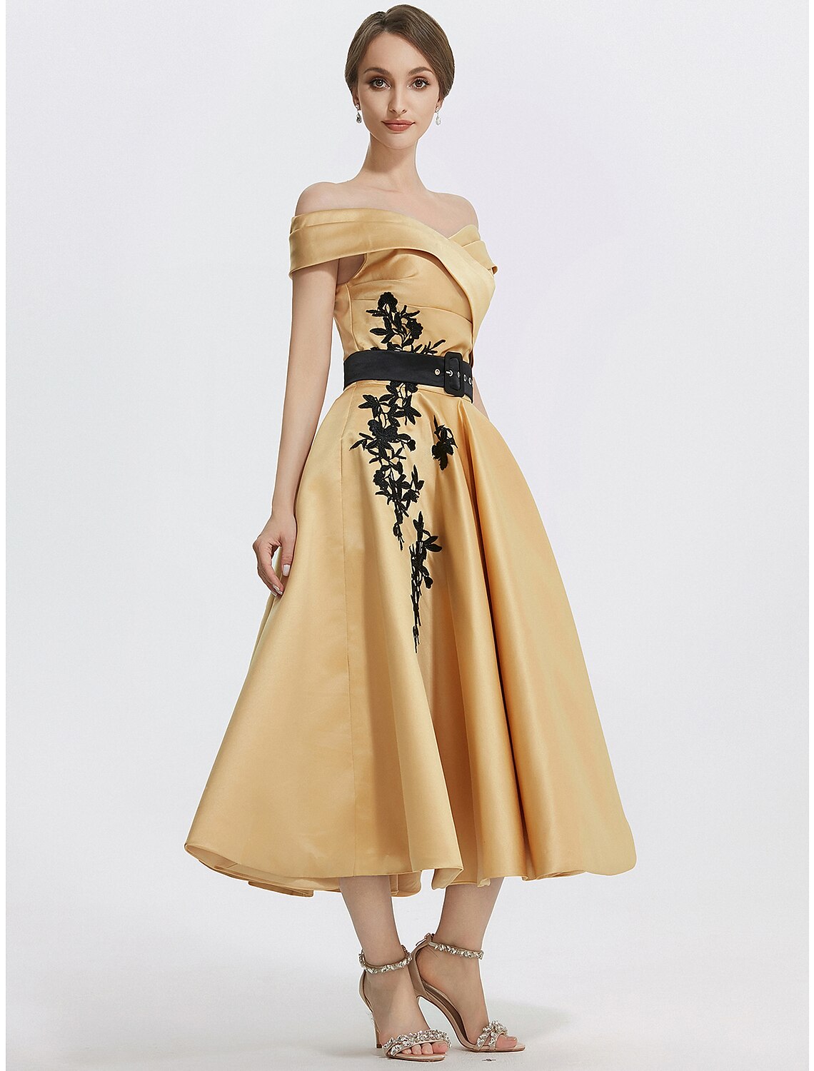 Close-up of delicate appliques on the off-shoulder satin dress.