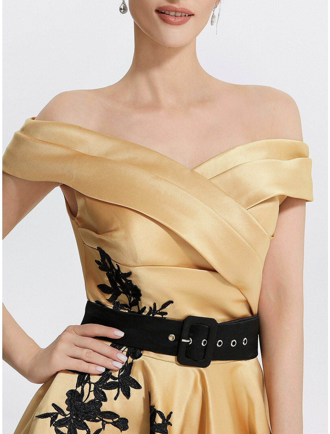 Model posing gracefully in the elegant satin off-shoulder dress.