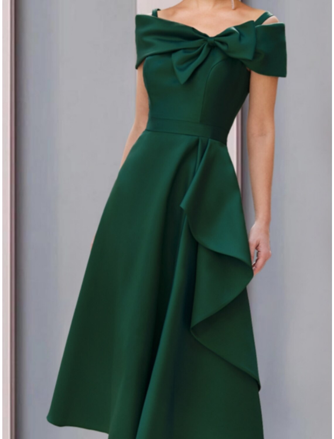 Back view of the elegant A-line off-shoulder satin tea-length dress.