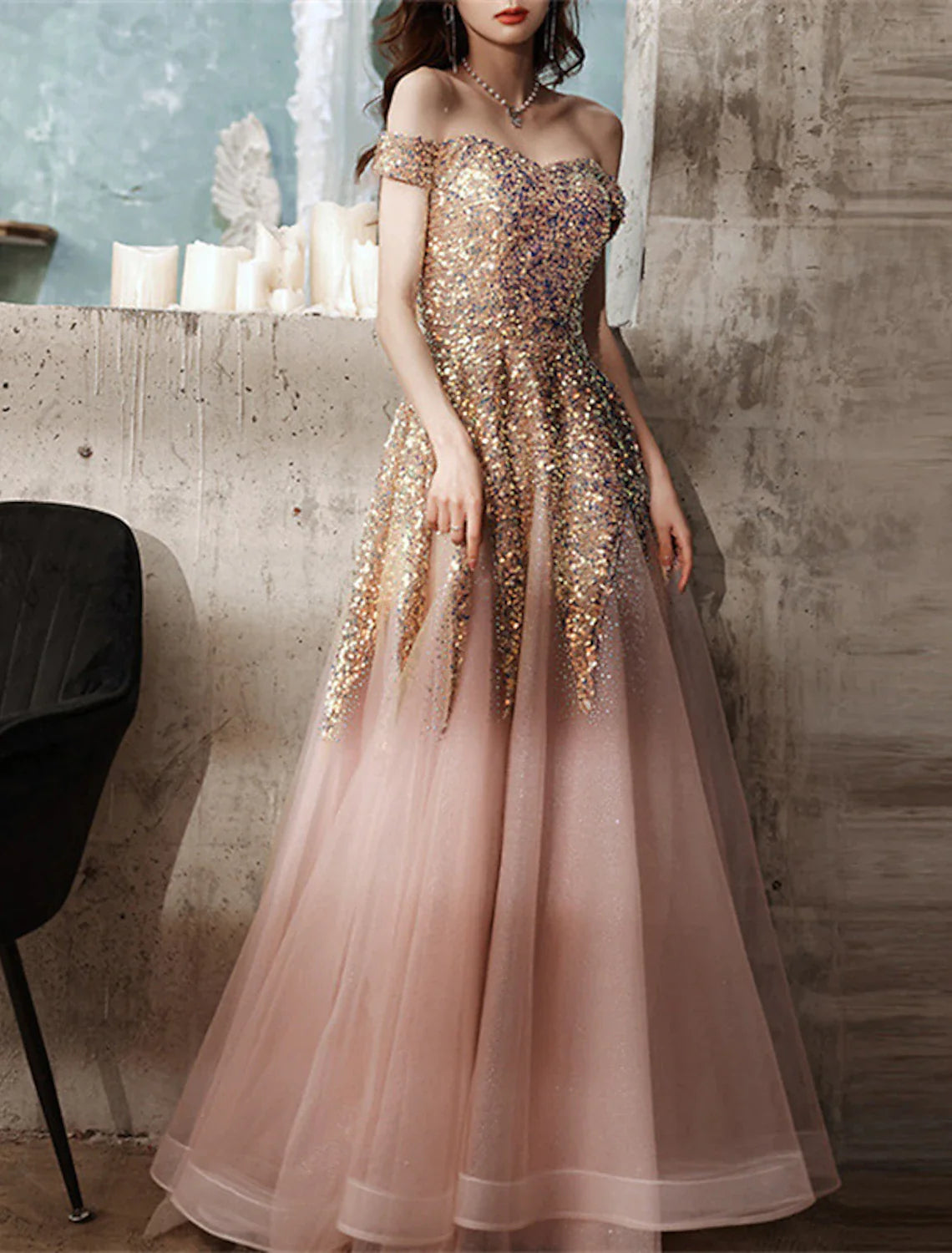 Woman posing in a floor-length sequin A-line gown.