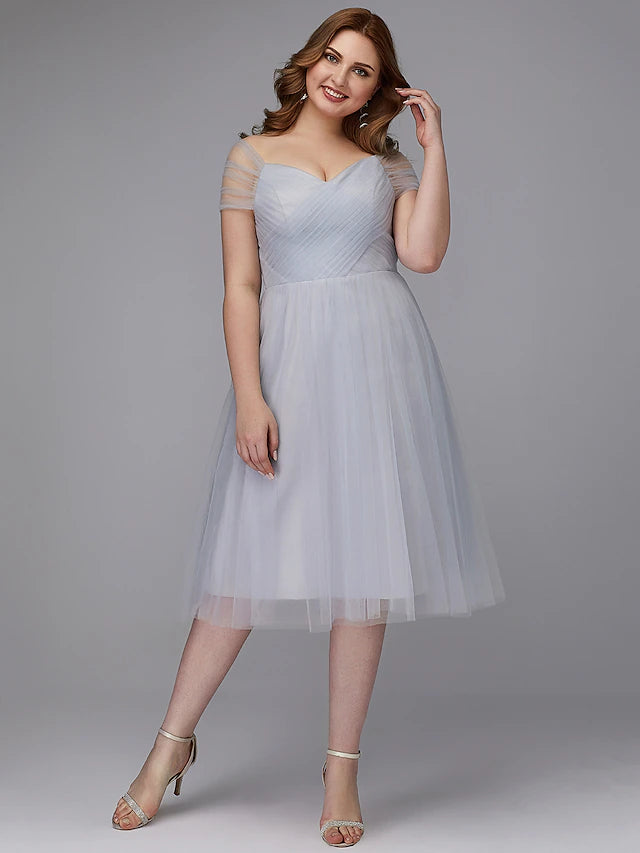 Elegant A-line off-shoulder tea length tulle dress with a sash, worn by a model.