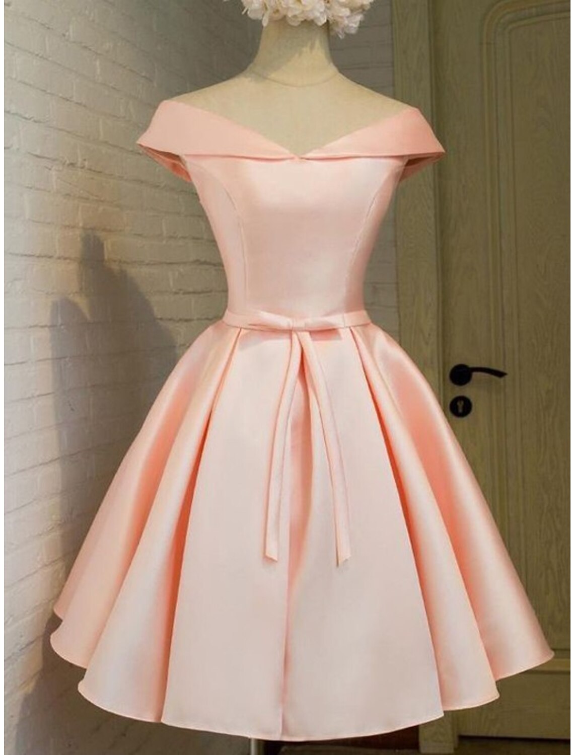 Elegant pink A-line off-shoulder satin dress with strappy details.
