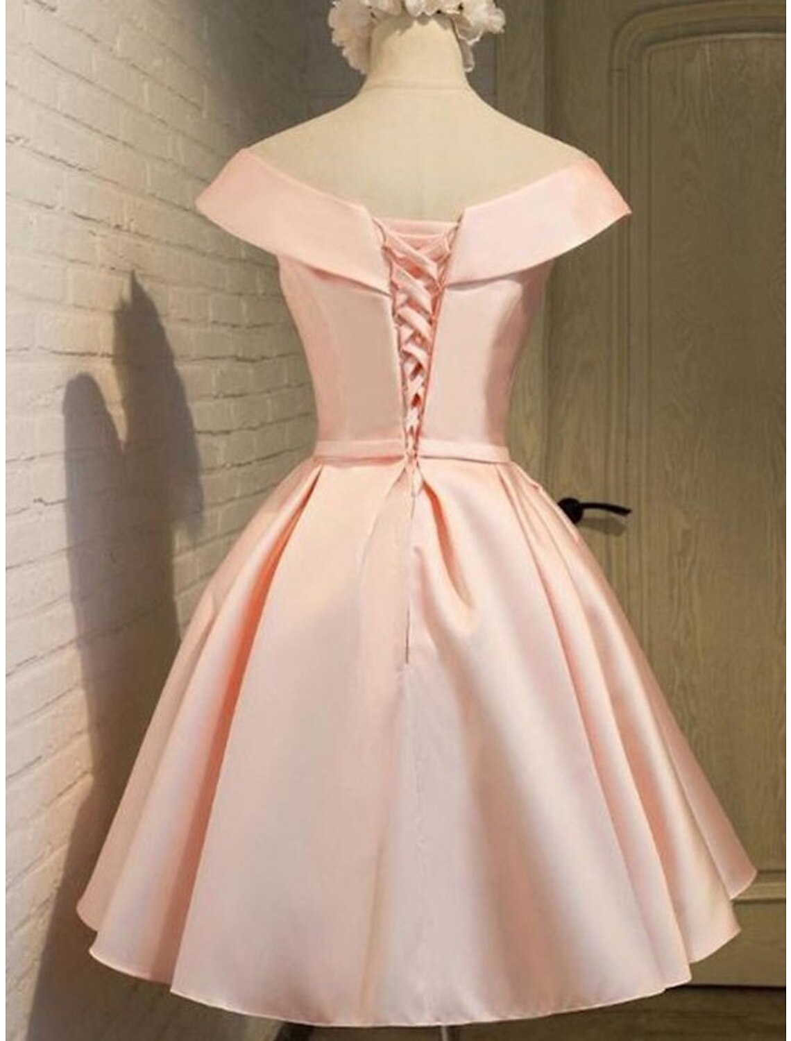 Back view of a pink A-line off-shoulder satin homecoming dress.