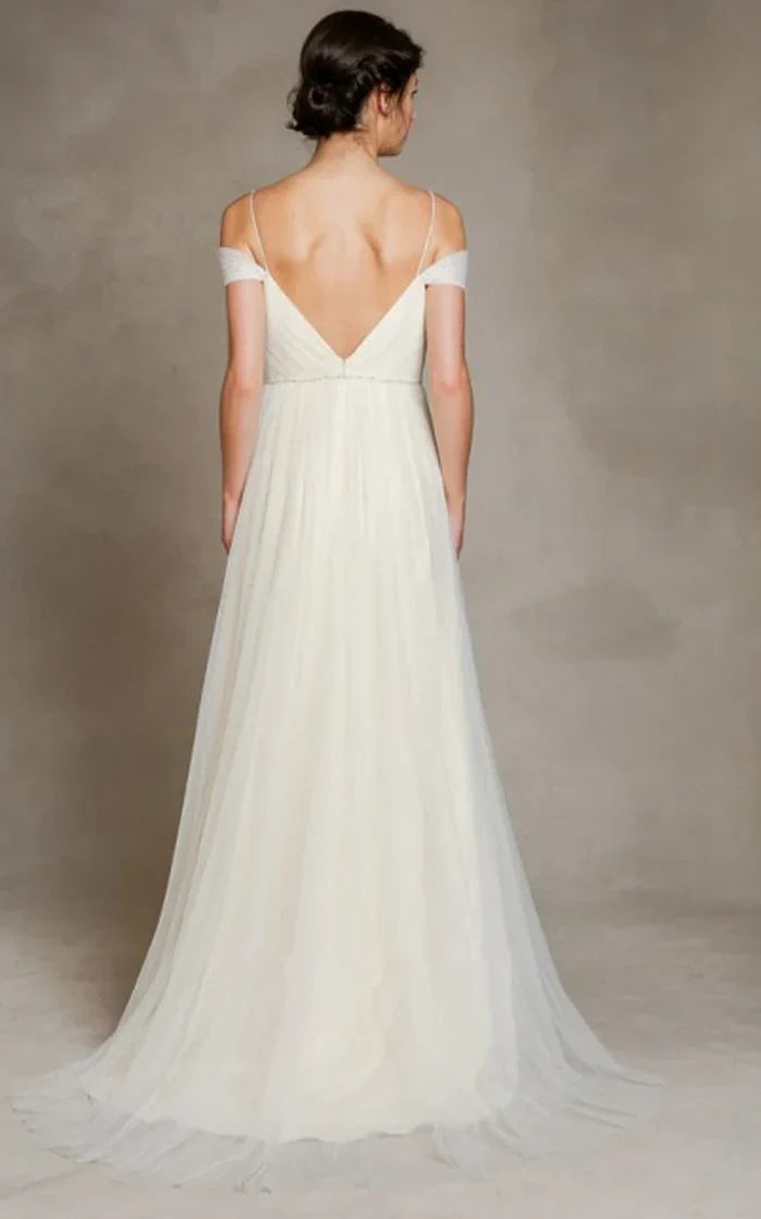 Back view of a flowing A-line wedding dress with off-shoulder design.