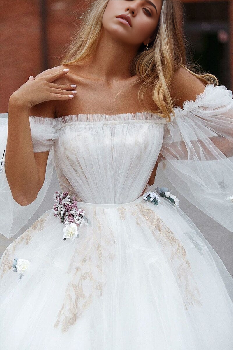 Close-up of the off-shoulder neckline and tulle fabric of the wedding dress.