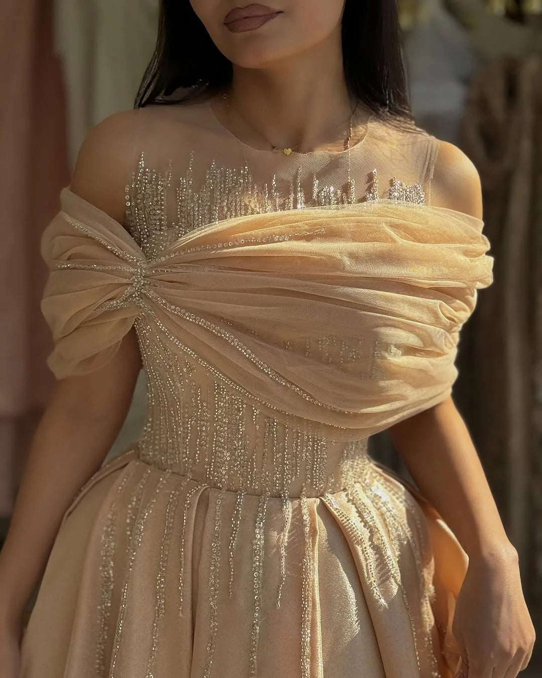 Model wearing A-line off-shoulder V-neck beaded gown.