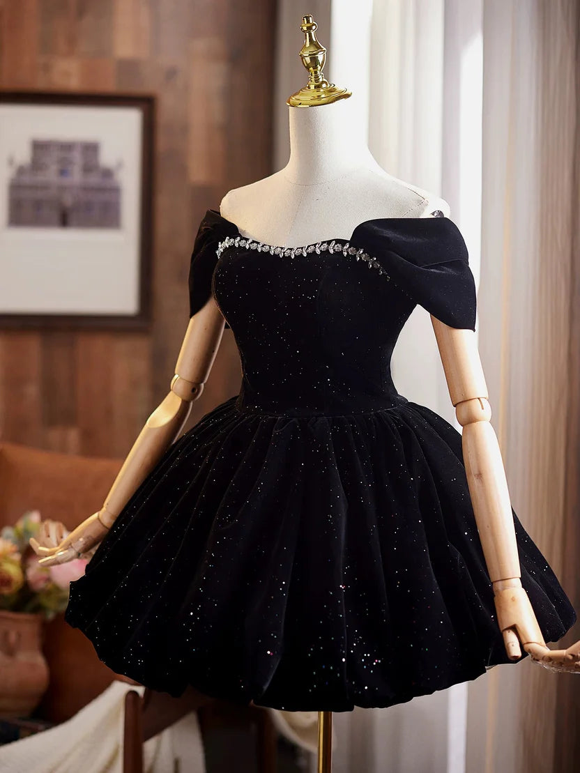 Off-shoulder black velvet dress with sparkling glitter details.