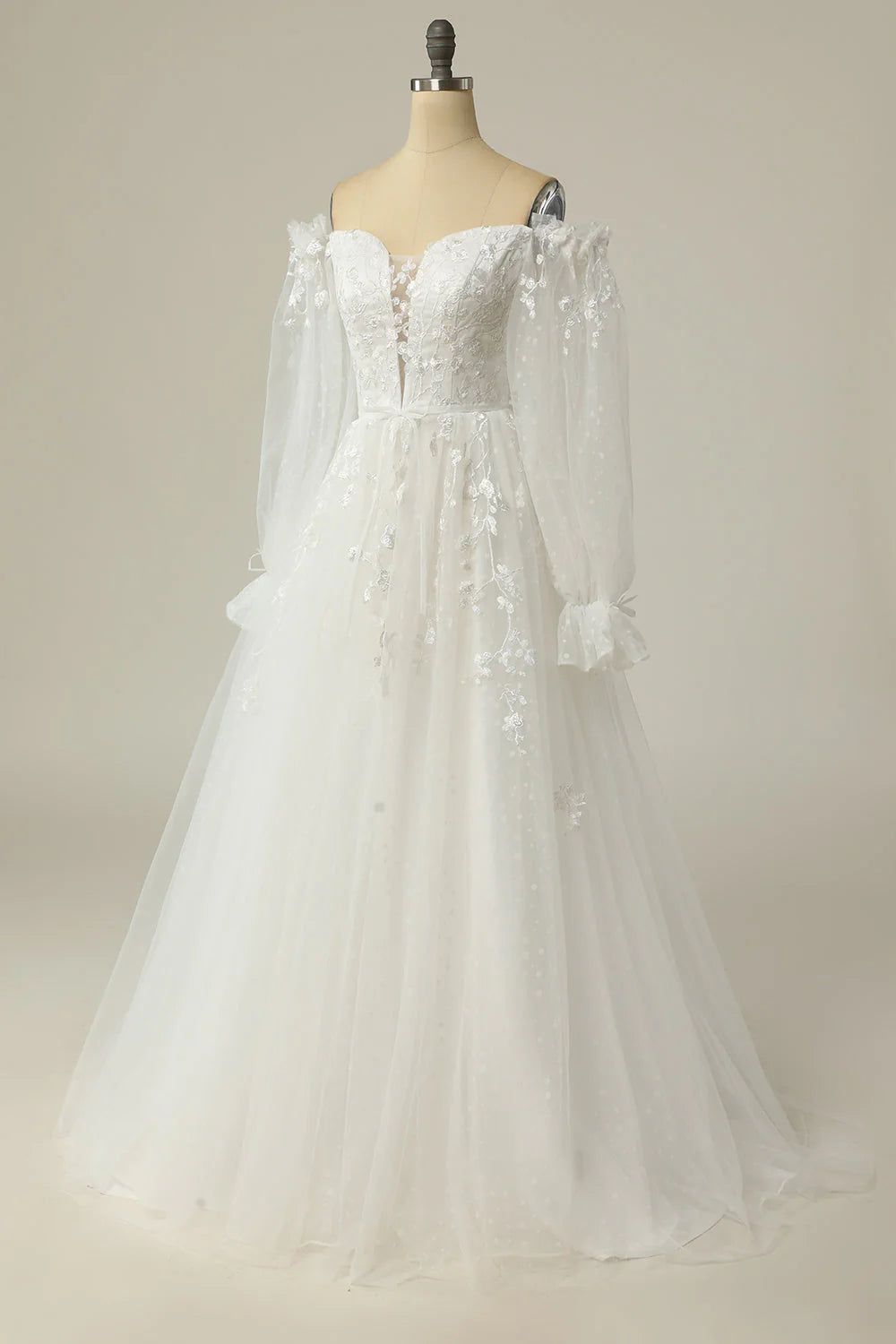 Side view of an A-line off-shoulder wedding dress with flowing skirt.