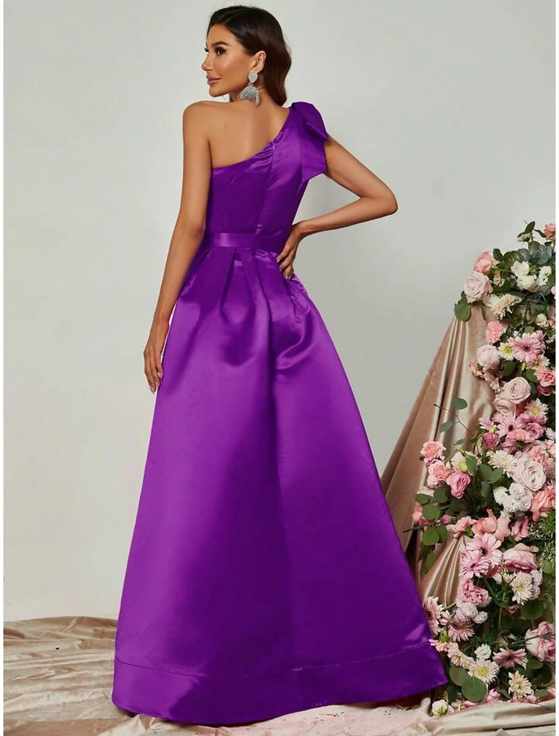 Close-up of the black satin fabric and pleats on the A-line one-shoulder formal dress.