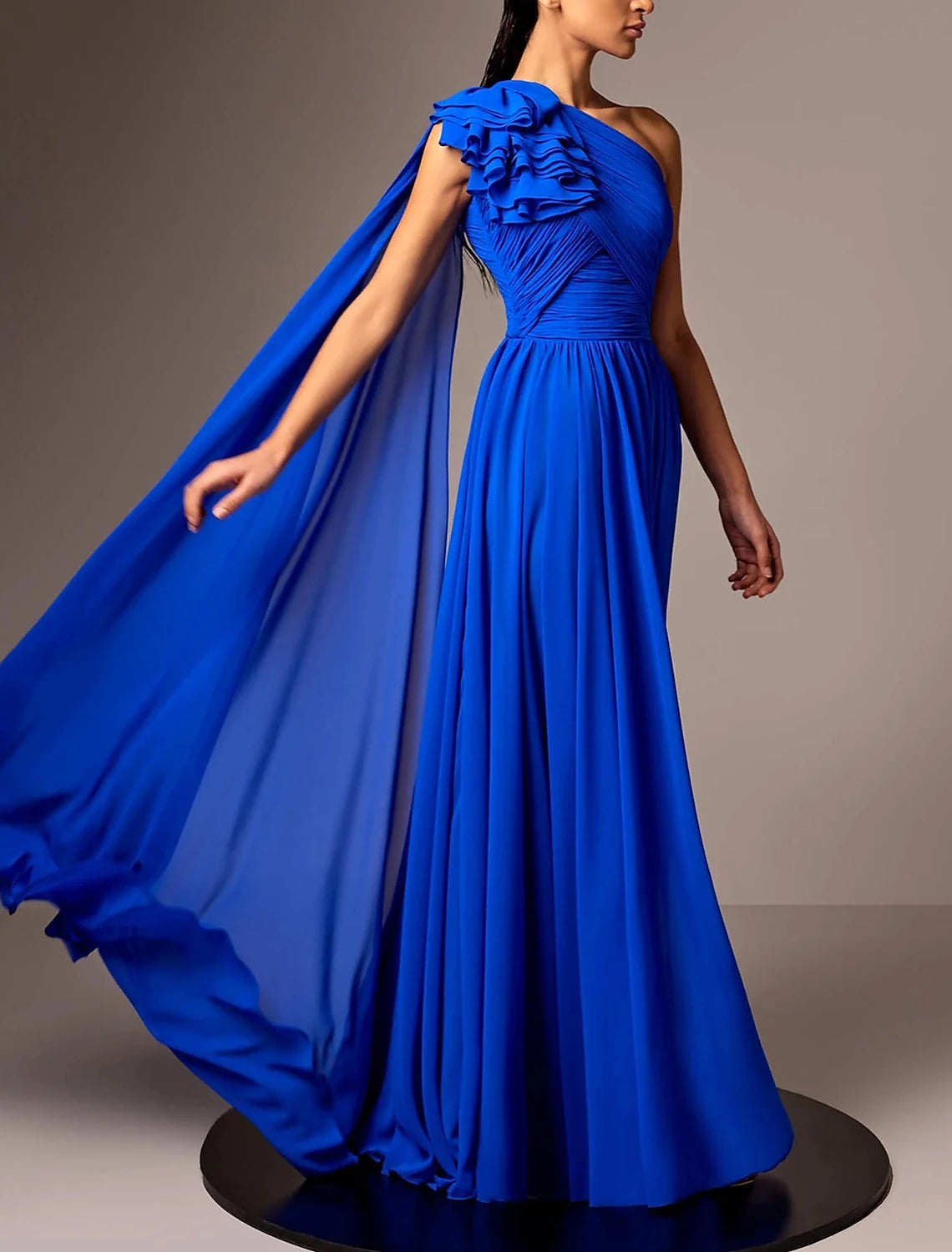 Close-up of the ruched shoulder and flower detail on the elegant chiffon evening gown.
