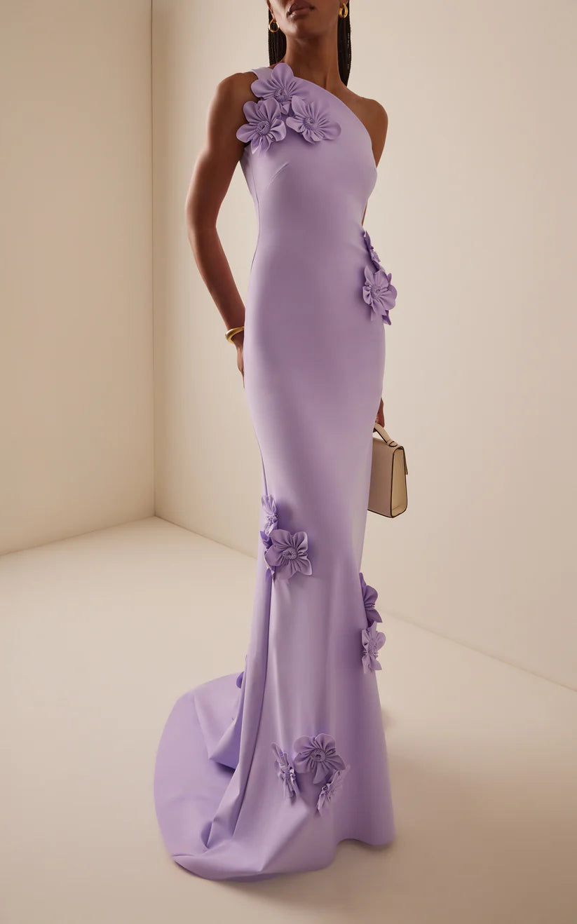 Woman wearing an elegant one-shoulder A-line prom dress with a sweep train.
