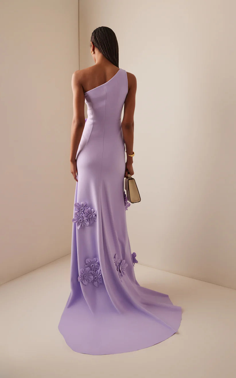 Side view of a woman in a one-shoulder A-line formal gown.