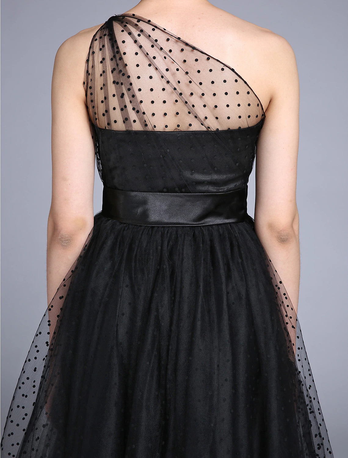 Close-up of the one-shoulder neckline and pleated detail on the dress.