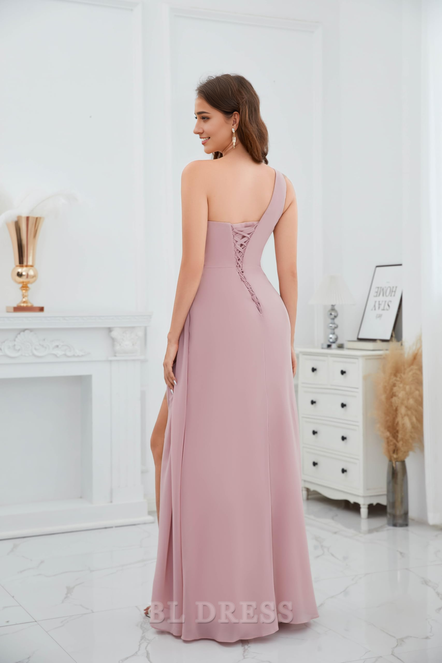 Side view of a woman in a teal A-line one-shoulder ruched chiffon dress.
